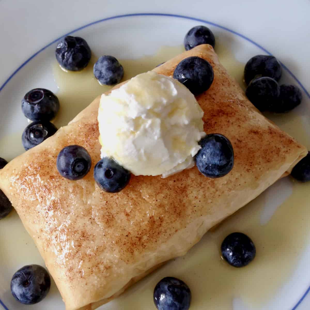 Greek breakfast pastry with blueberries and syrup and yogurt. Crispiest Sweet Bougatsa.
