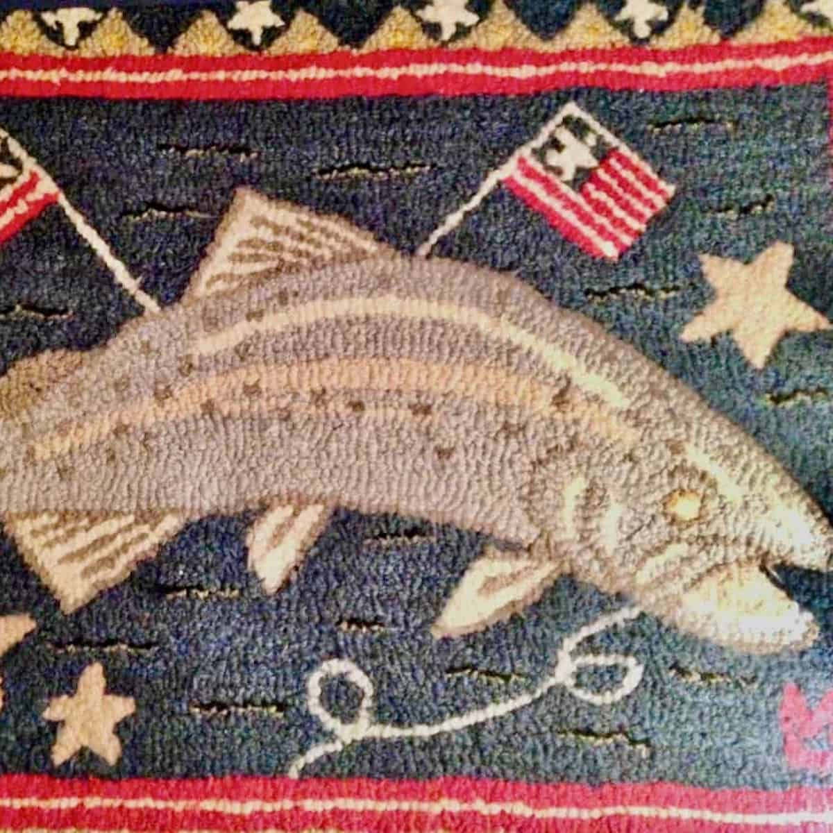 Hooked rug with fish and flags.