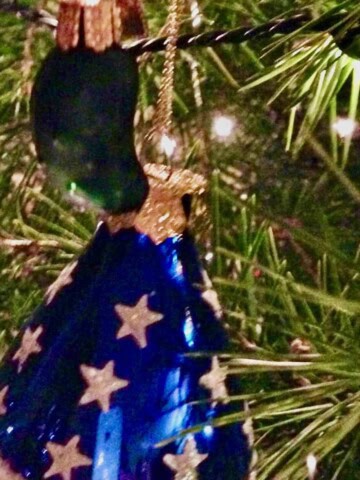 Pickle and American flag xmas ornaments on tree.