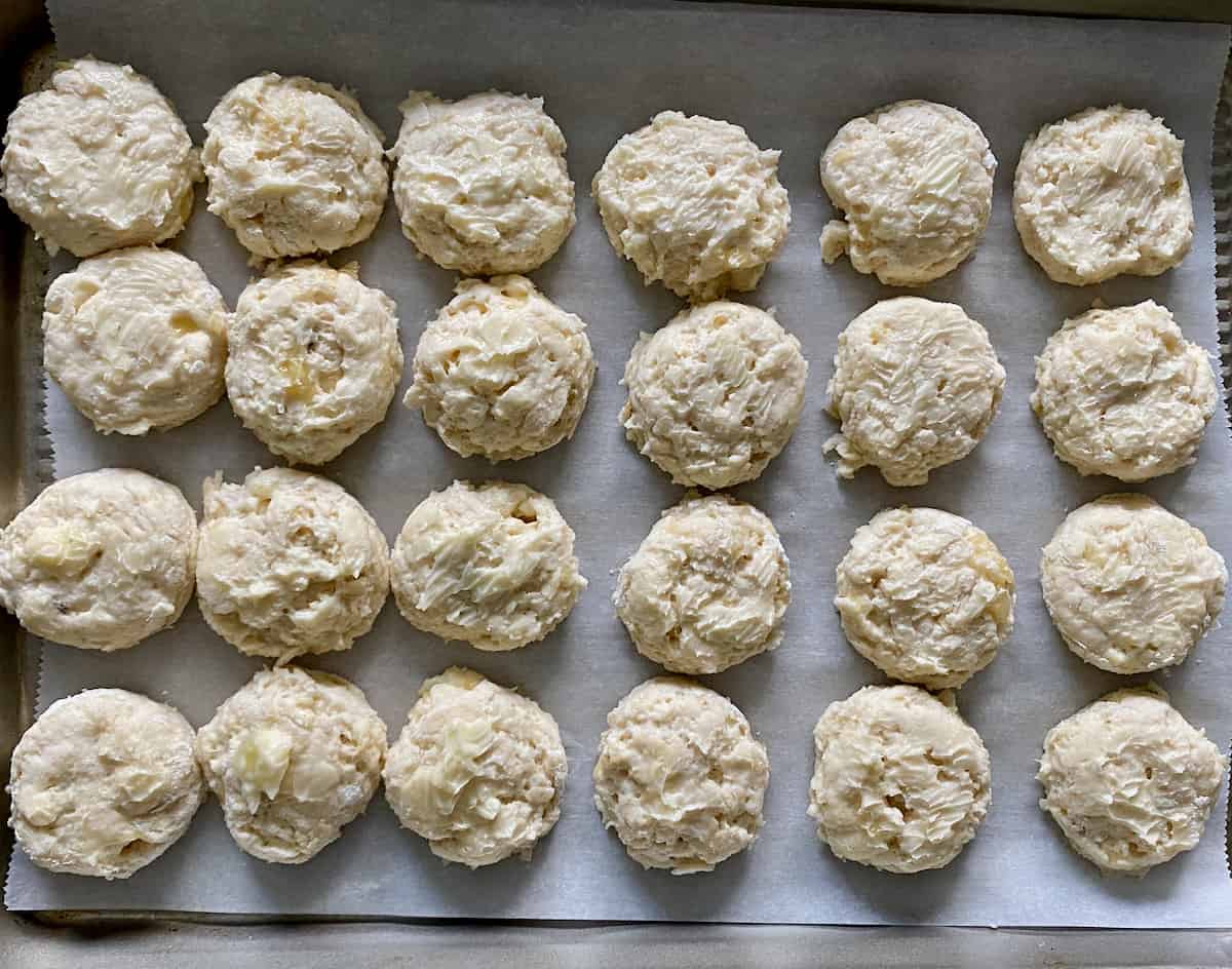 Cut out biscuits arranged on baking sheet.