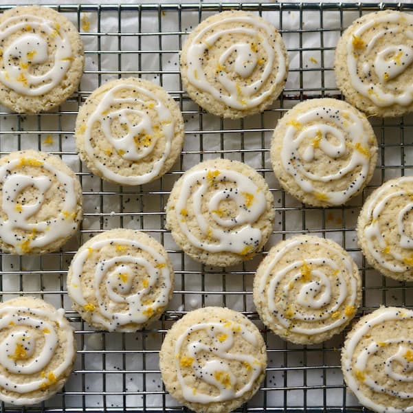 Glazed lemon poppy seed cookies on cooling rack.