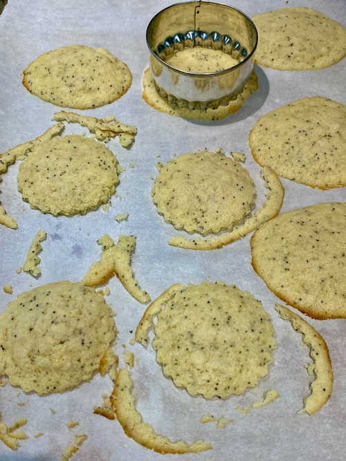 Shaping baked cookies with a cutter.