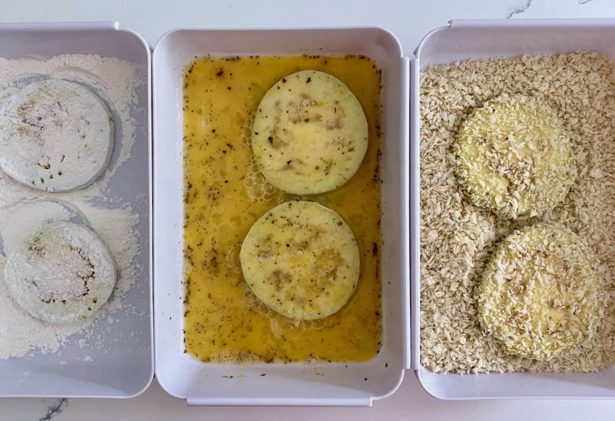 Dredging eggplant in flour, egg wash and bread crumbs.