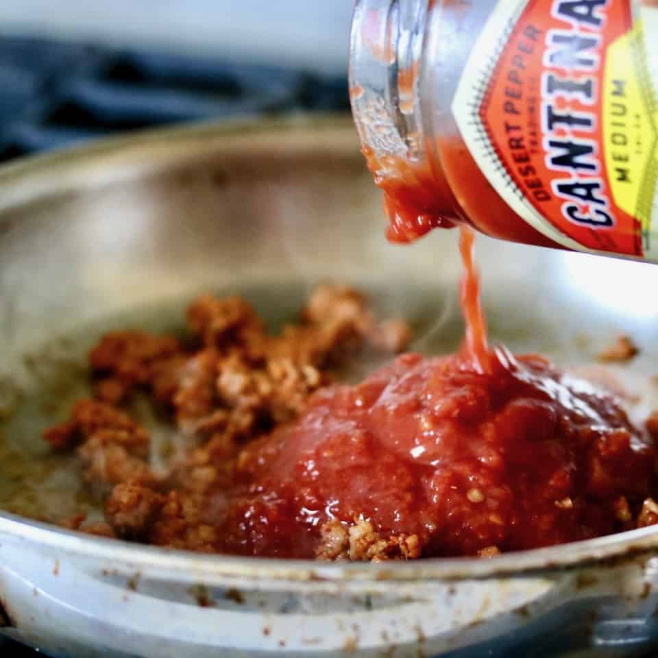 Adding the salsa to the skillet.