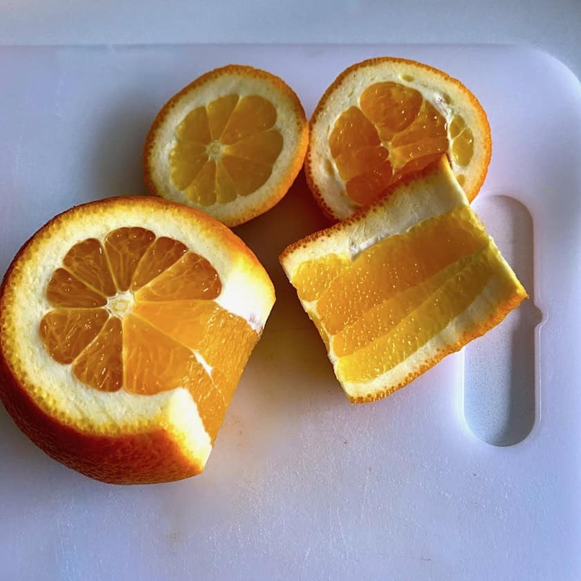 Slicing peel off of an orange.