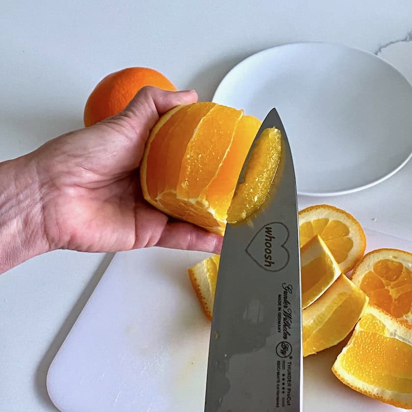 Removing orange supremes from an orange.