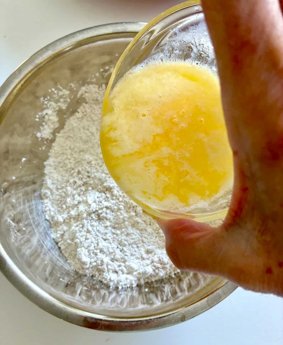 Adding melted butter to flour mixture.