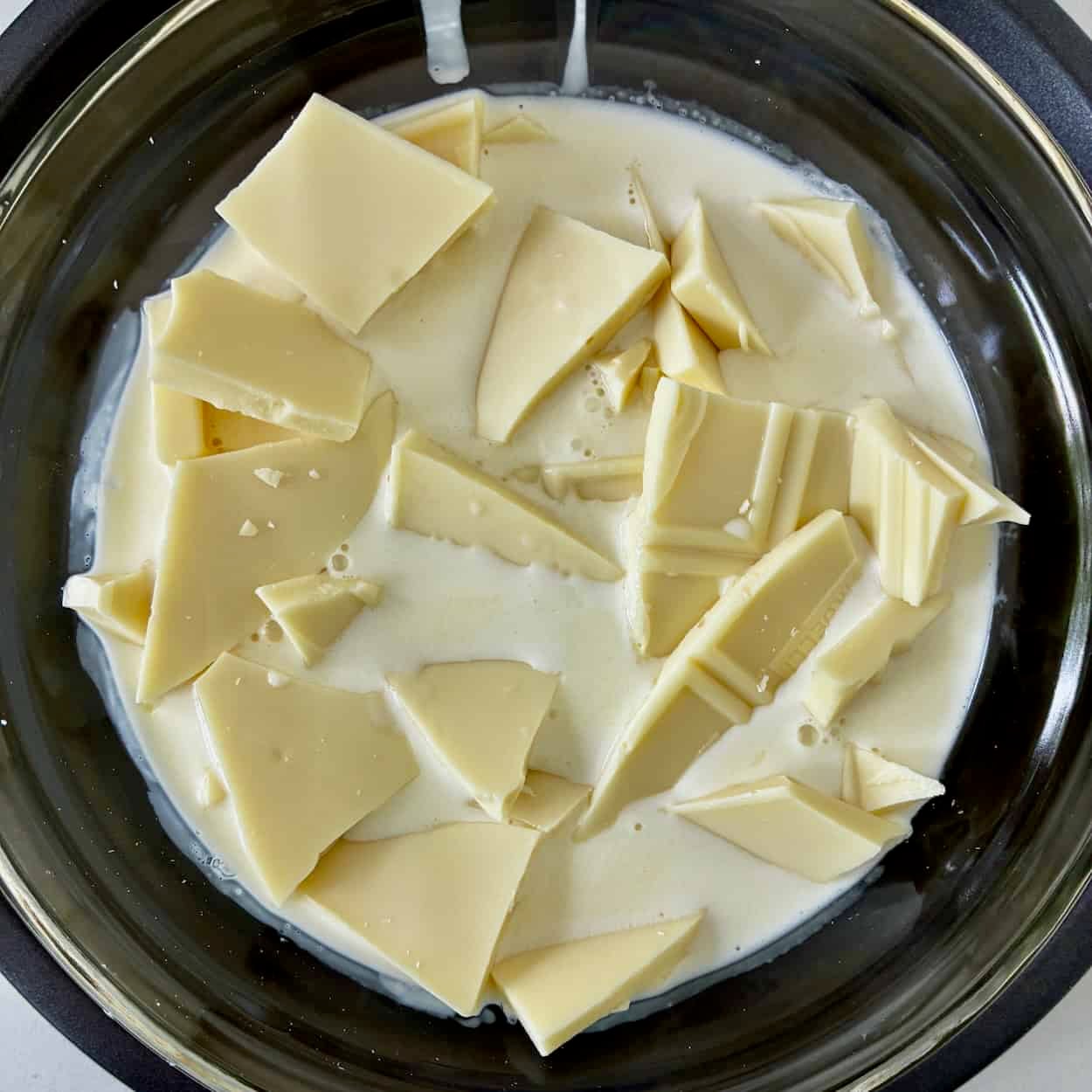 Melting white chocolate in cream.