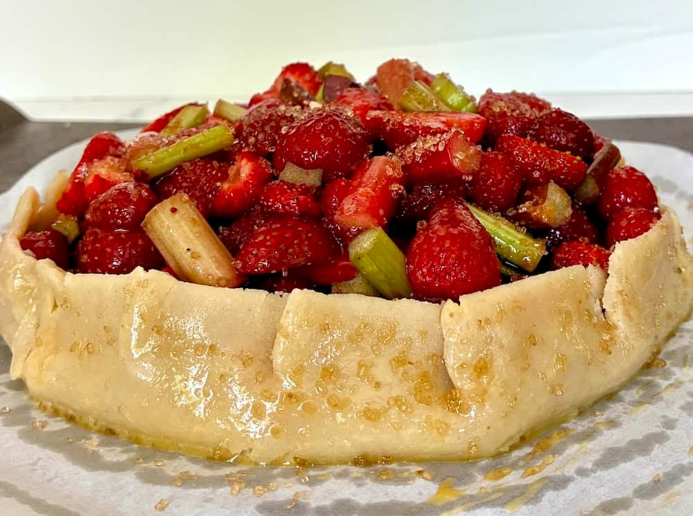 Strawberry and rhubarb fruit tart with flaky crust ready to bake.
