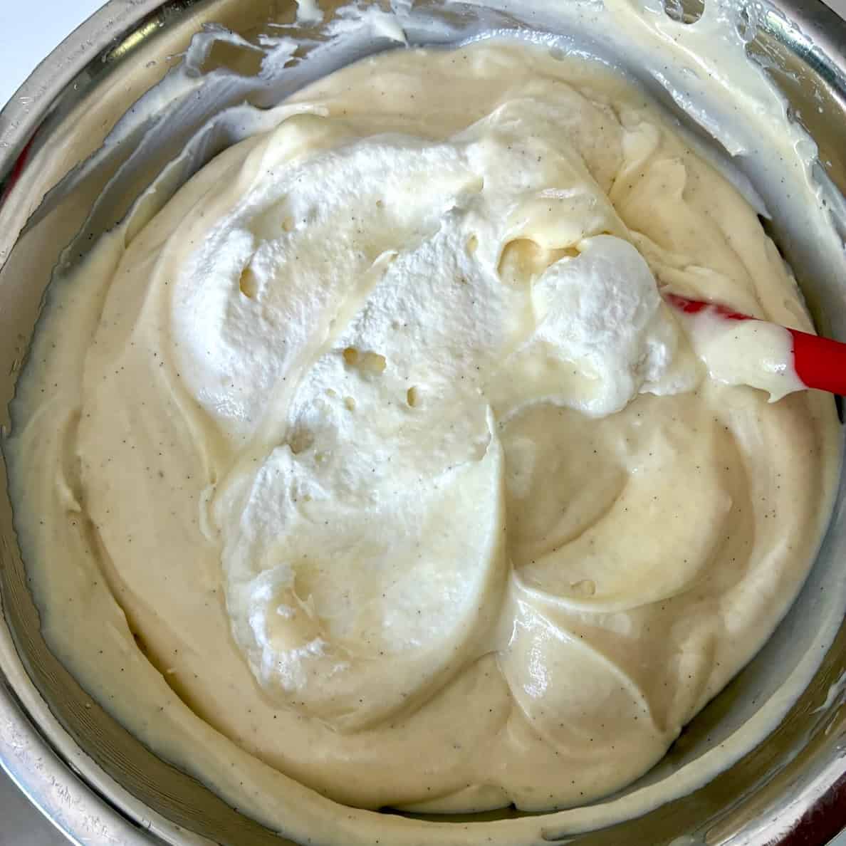 Folding whipped cream into mousse.