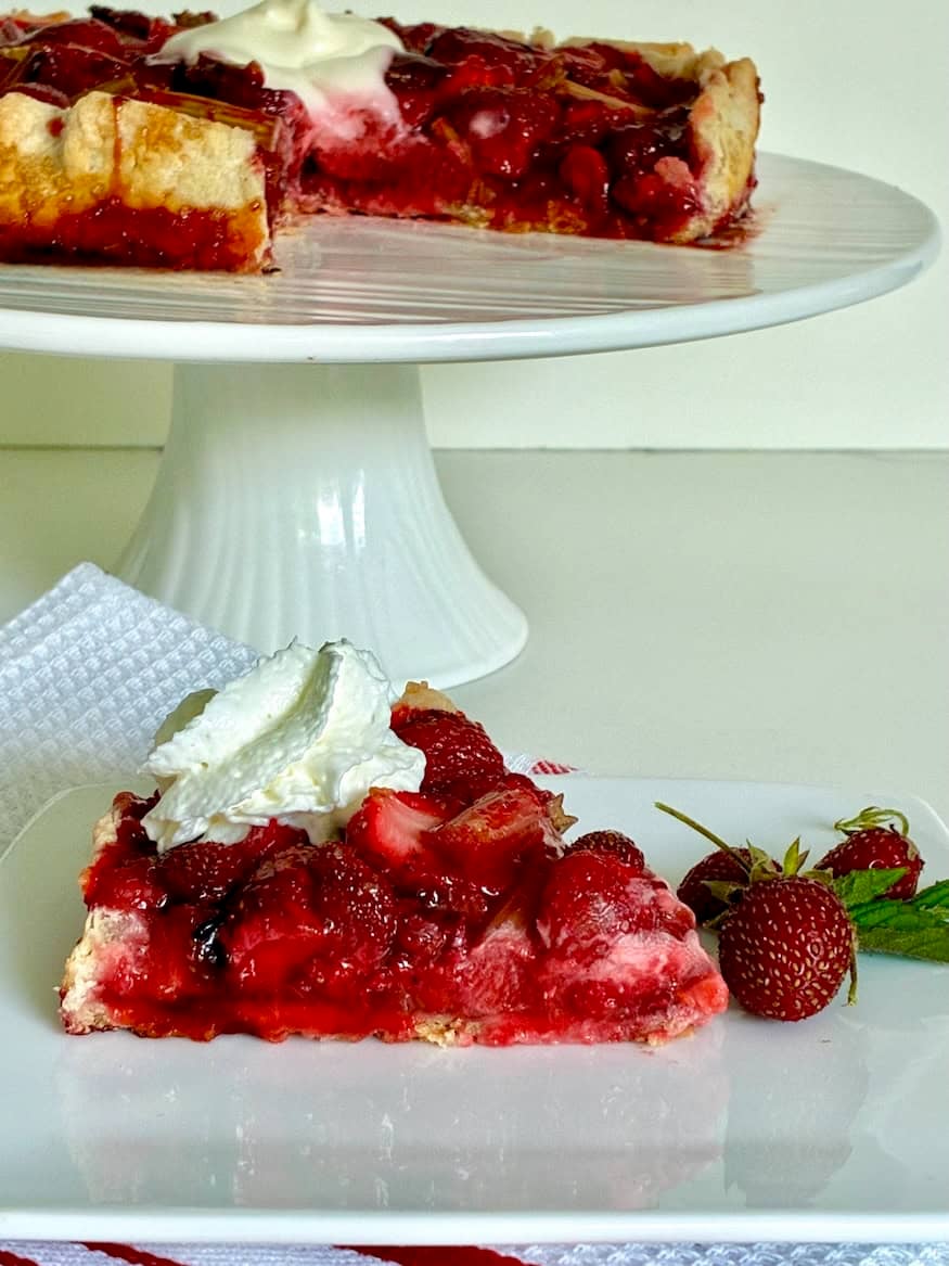 Homemade berry galette with fresh strawberries, rhubarb and whipped cream.