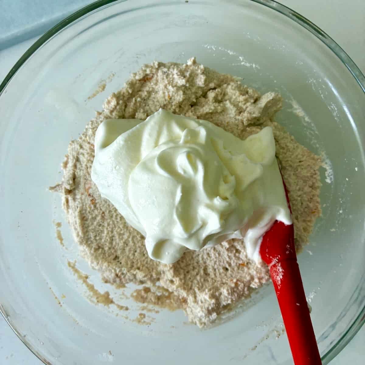 Folding whipped cream into cannoli filling.