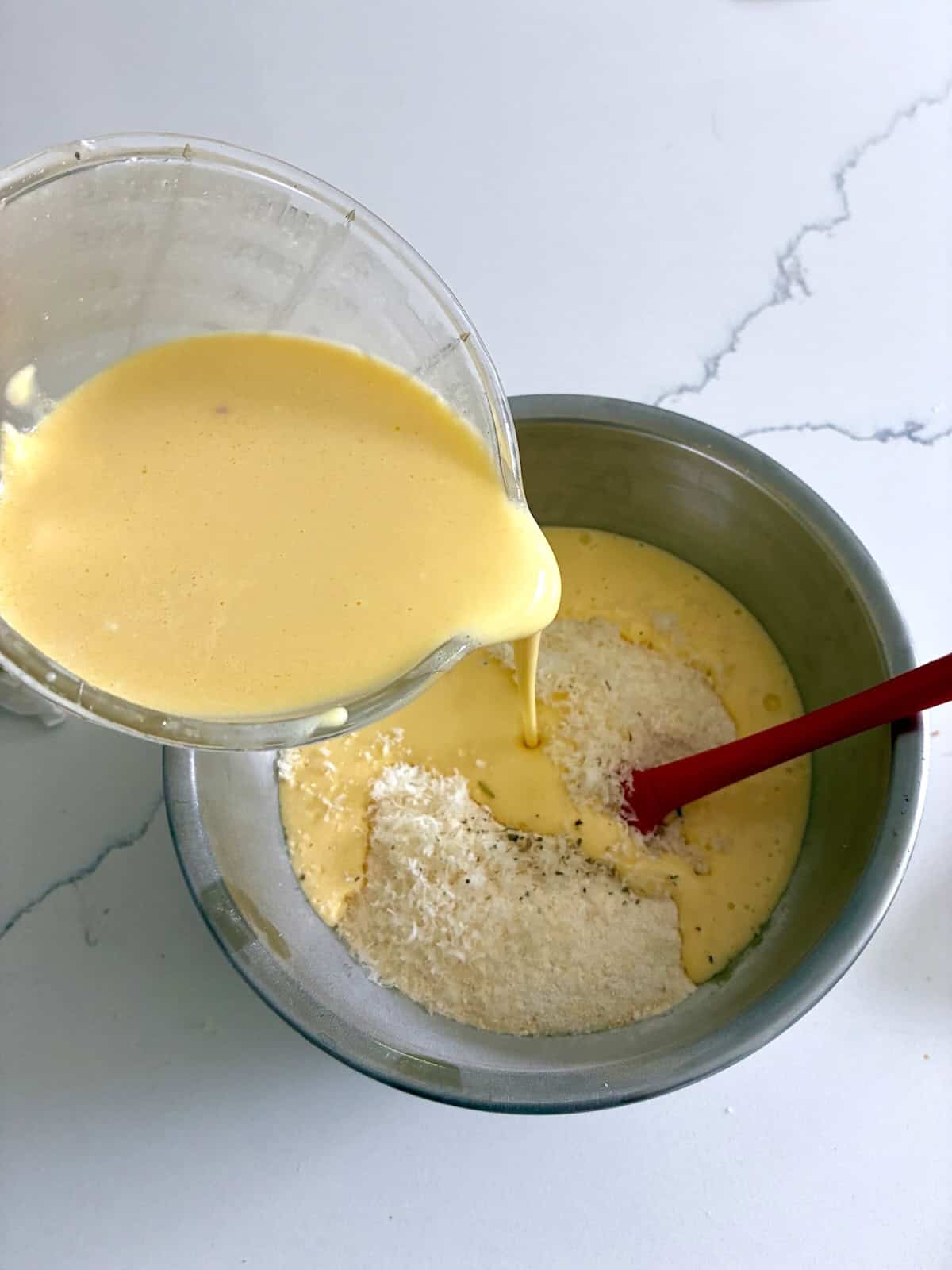 Mixing wet and dry cornbread casserole ingredients.