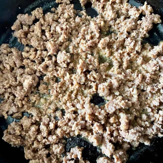 Ground sausage being cooked in a skillet.