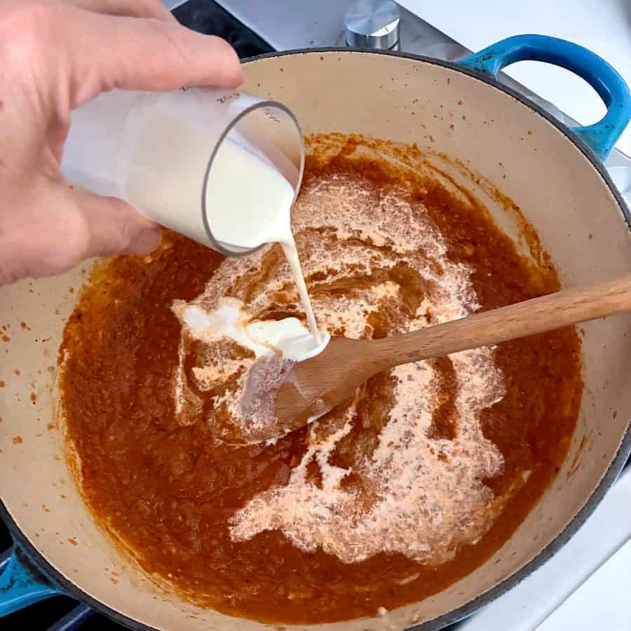 Adding cream to pot.