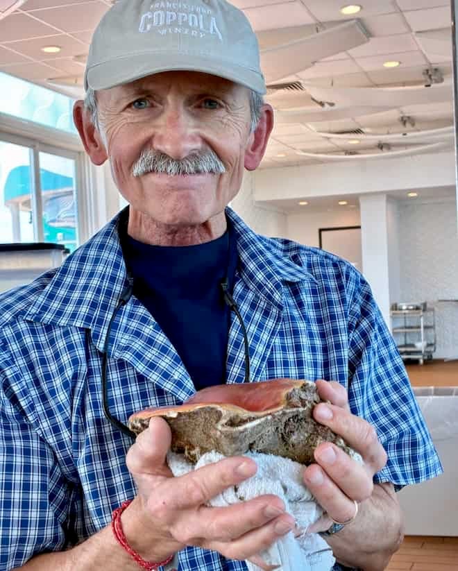 My husband holding a conch shell.