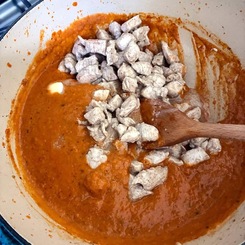 Stirring chicken into sauce.