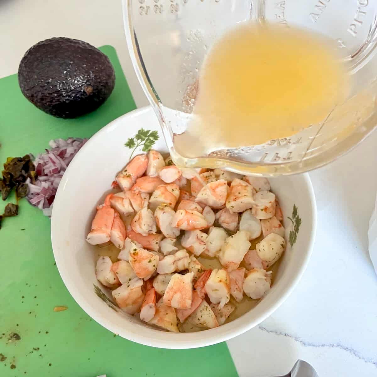 Adding citrus juice to shrimp.