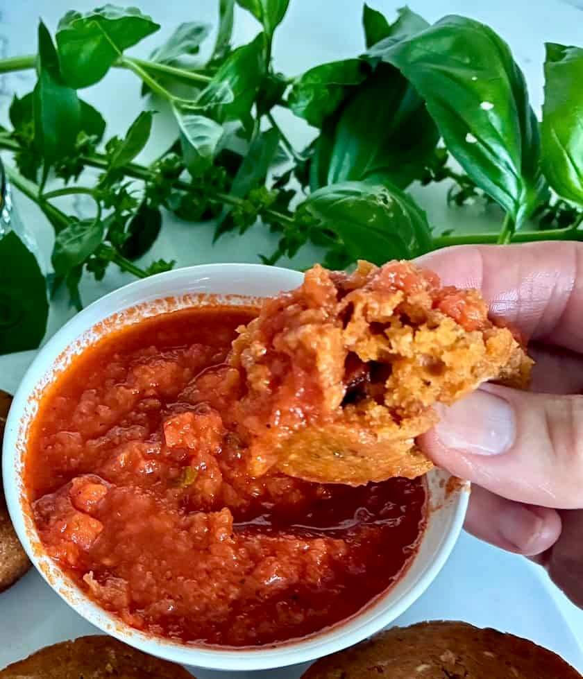 Dipping muffin in pizza sauce.