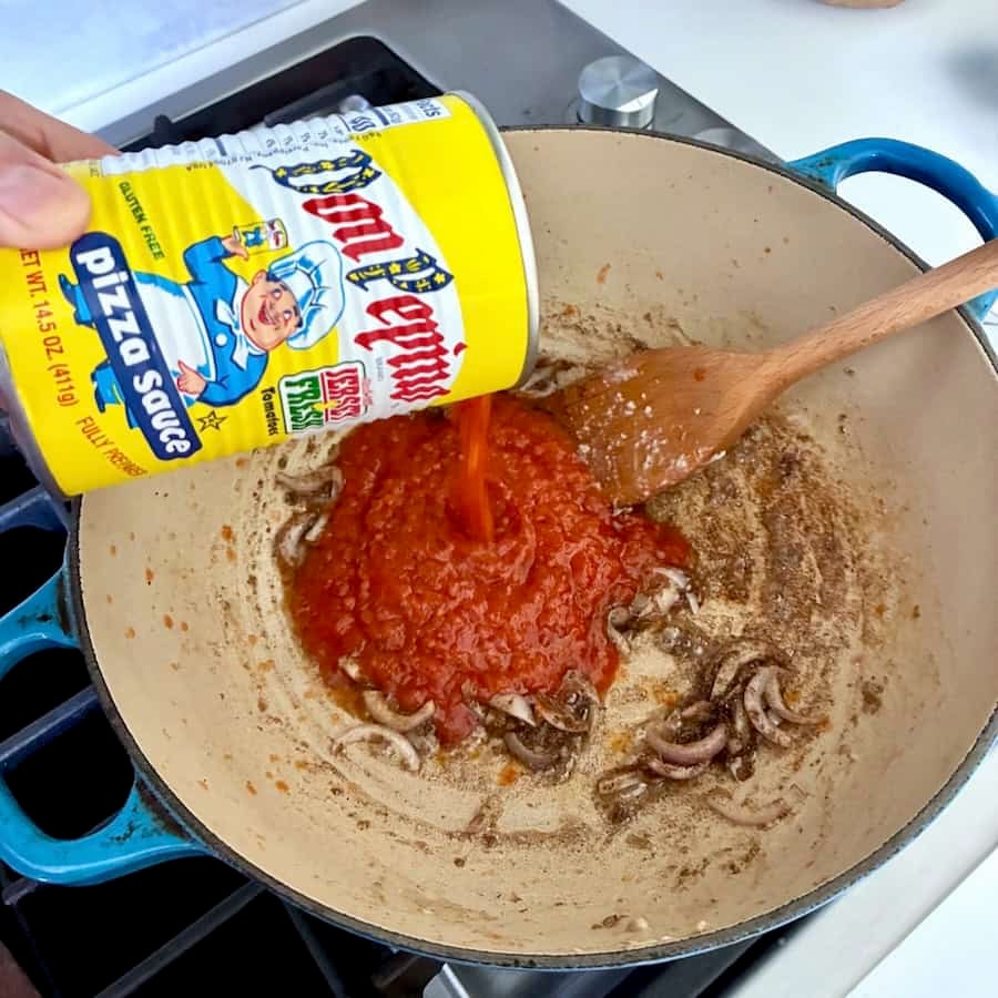 Pouring pizza sauce into pot.