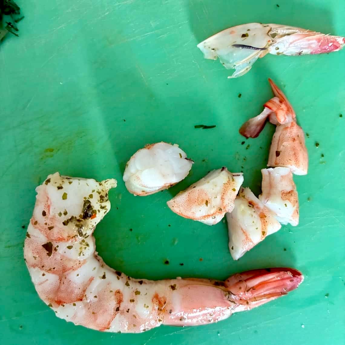 Dicing shrimp into bite-size pieces.